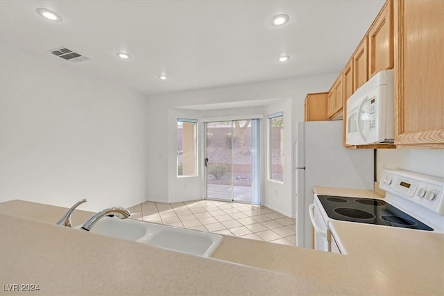 kitchen with white appliances, sink, and light tile patterned floors