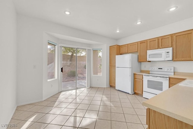 kitchen featuring sink, light tile patterned flooring, and white appliances