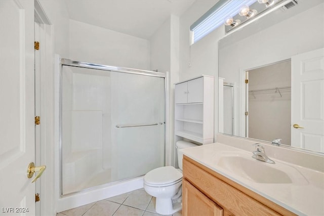 bathroom with tile patterned flooring, vanity, toilet, and a shower with shower door