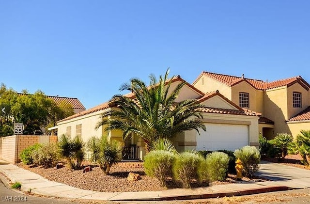 mediterranean / spanish-style home with a garage