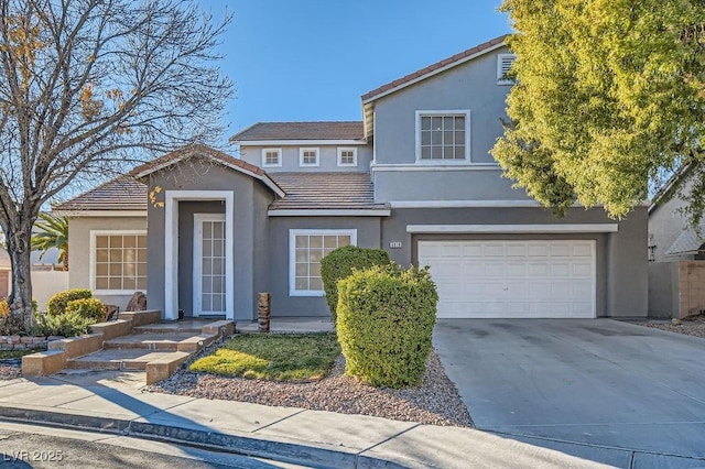 traditional home with a garage, concrete driveway, a tiled roof, and stucco siding