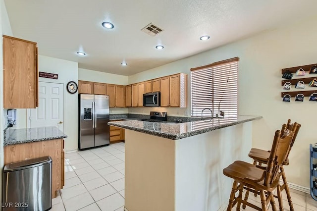6019 Orca Lilly St, North Las Vegas, NV 89031 - kitchen with a kitchen breakfast bar, stainless steel appliances, visible vents, light tile patterned flooring, and a peninsula
