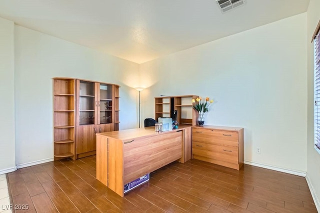 office area with dark wood-type flooring, visible vents, and baseboards