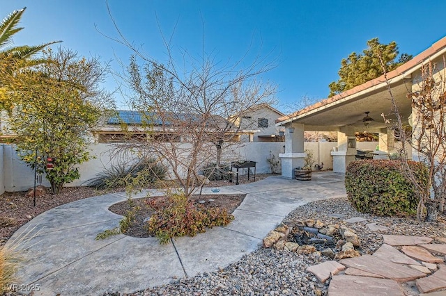 view of yard featuring a fenced backyard, ceiling fan, and a patio