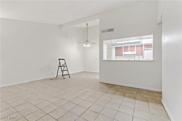 tiled spare room featuring ceiling fan, sink, and lofted ceiling with beams