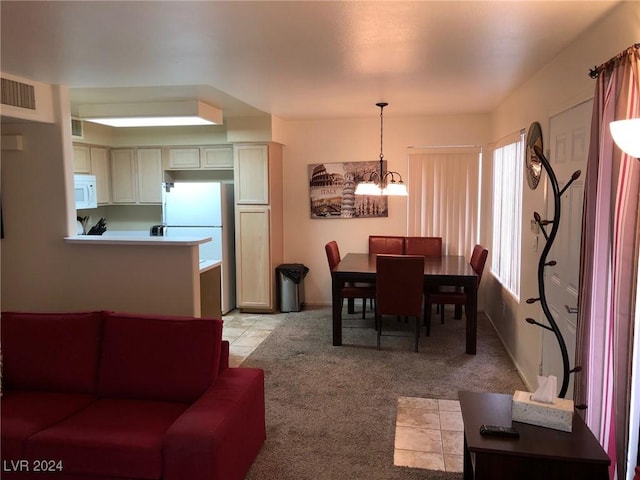 dining room featuring light colored carpet and a notable chandelier