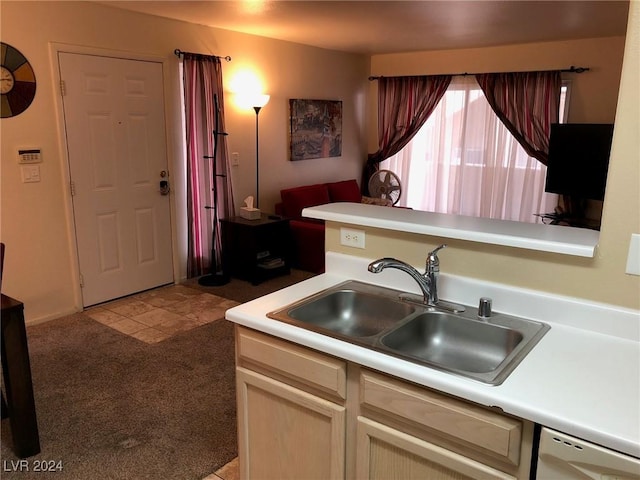 kitchen featuring dishwasher, sink, light colored carpet, and light brown cabinets