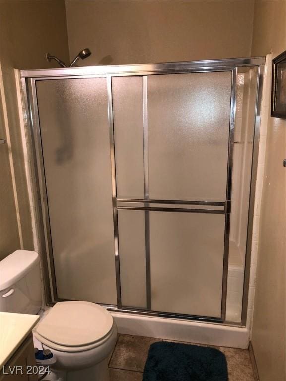 bathroom featuring walk in shower, tile patterned floors, vanity, and toilet