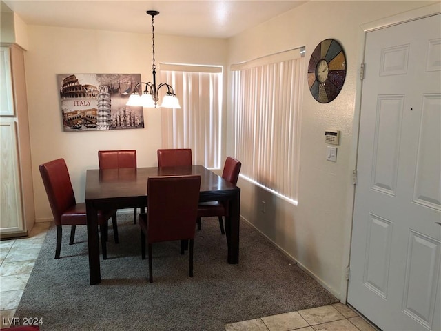 dining room with light tile patterned floors and a notable chandelier