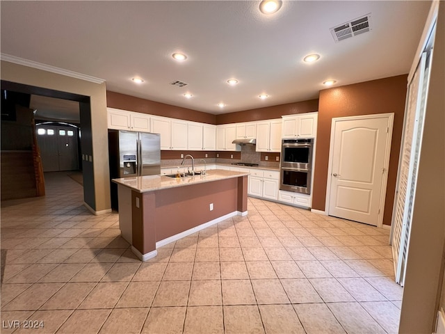 kitchen featuring a kitchen island with sink, sink, light tile patterned floors, appliances with stainless steel finishes, and white cabinetry