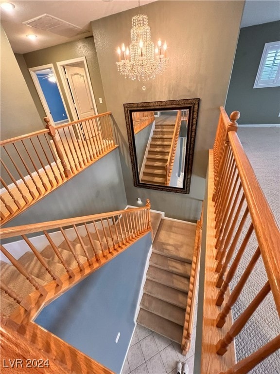 staircase featuring tile patterned flooring and an inviting chandelier