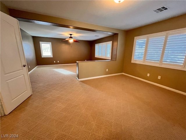 unfurnished room featuring ceiling fan and light carpet