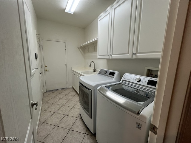 laundry area with cabinets, light tile patterned floors, separate washer and dryer, and sink