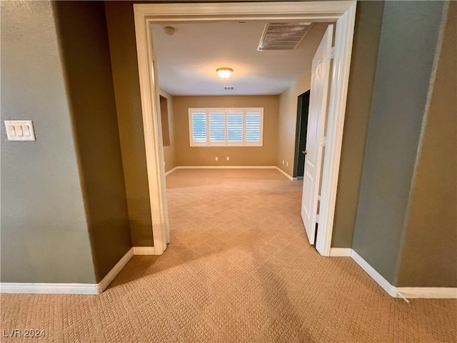 hallway featuring light colored carpet