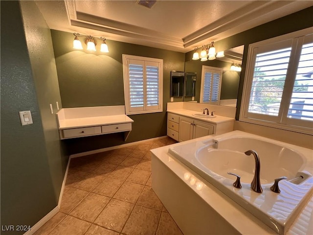 bathroom with tile patterned floors, vanity, a raised ceiling, and a bathing tub