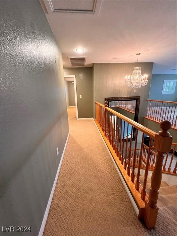 corridor featuring carpet and a chandelier