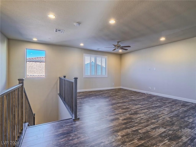 unfurnished room with dark hardwood / wood-style flooring, ceiling fan, and a wealth of natural light