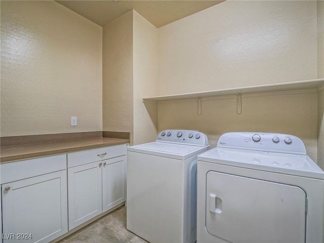 laundry area featuring washing machine and dryer and cabinets