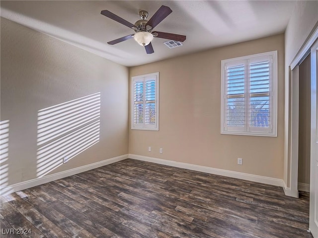 empty room featuring ceiling fan and dark wood-type flooring