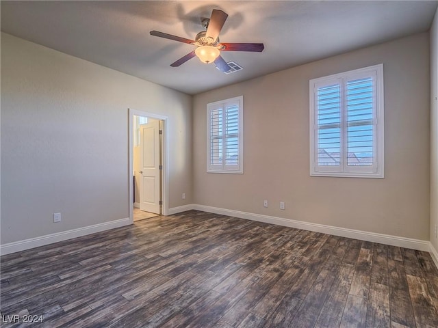 empty room featuring dark hardwood / wood-style flooring and ceiling fan