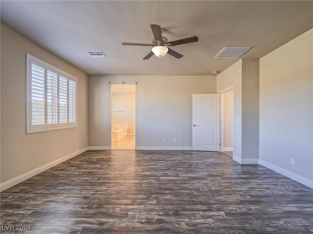 empty room with ceiling fan, a textured ceiling, and dark hardwood / wood-style floors