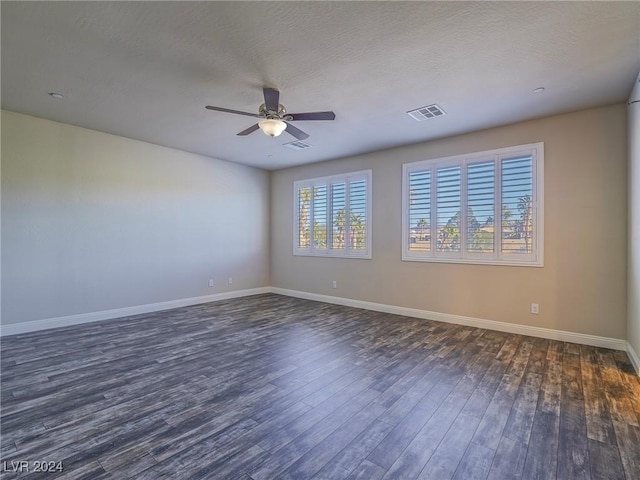 spare room with ceiling fan, dark hardwood / wood-style flooring, and a textured ceiling