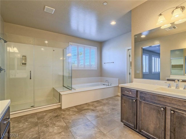 bathroom featuring shower with separate bathtub, a wealth of natural light, and vanity