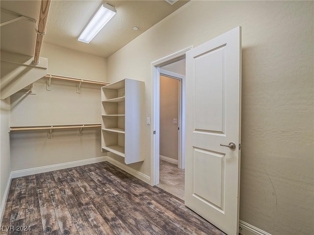 walk in closet with dark hardwood / wood-style flooring