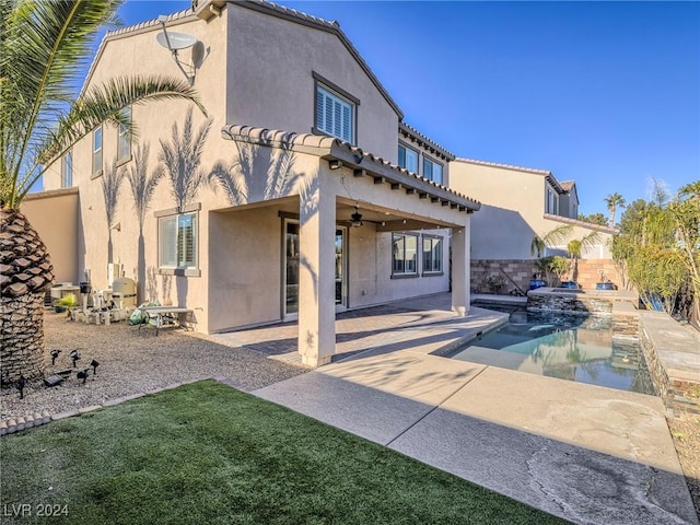 back of house featuring ceiling fan, a patio, and a fenced in pool