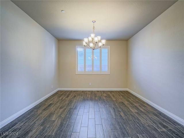 unfurnished room with a notable chandelier and dark hardwood / wood-style flooring