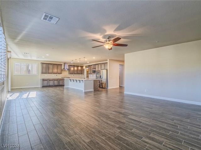 unfurnished living room with ceiling fan