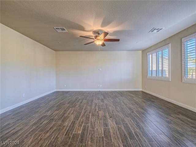 empty room with ceiling fan, a textured ceiling, and dark hardwood / wood-style floors