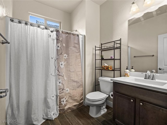 bathroom featuring a shower with shower curtain, vanity, and toilet