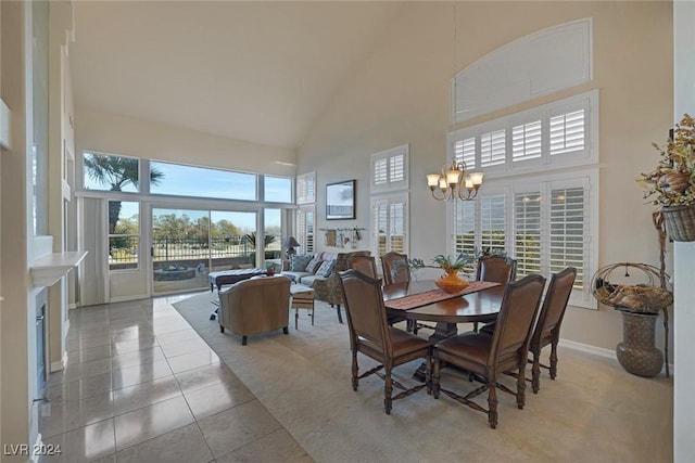 tiled dining room featuring an inviting chandelier and a high ceiling