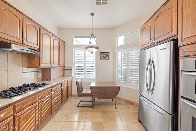 kitchen featuring tasteful backsplash, appliances with stainless steel finishes, decorative light fixtures, and light tile patterned floors