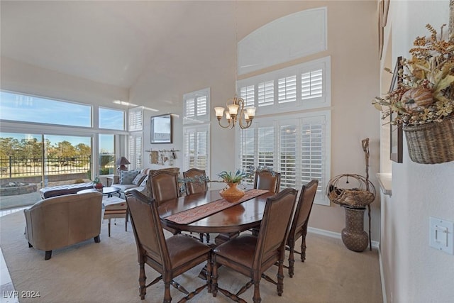 dining area featuring light colored carpet, a towering ceiling, and a notable chandelier