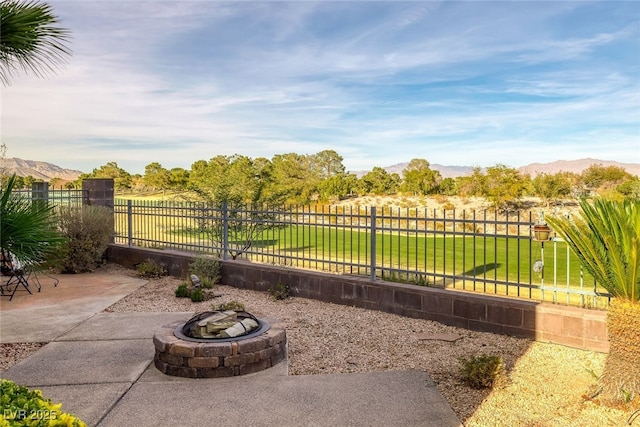 view of yard with a mountain view, a patio area, and an outdoor fire pit