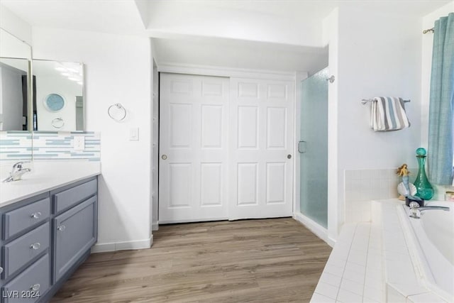 bathroom featuring vanity, separate shower and tub, and wood-type flooring