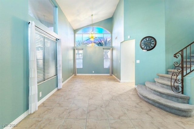 tiled foyer with high vaulted ceiling and a notable chandelier