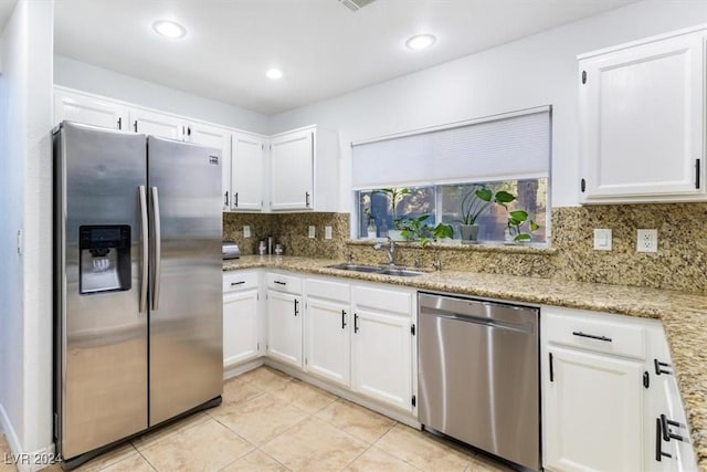 kitchen featuring light stone counters, stainless steel appliances, sink, white cabinets, and light tile patterned flooring