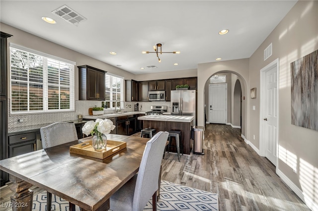 dining room featuring a notable chandelier, light wood-type flooring, and sink