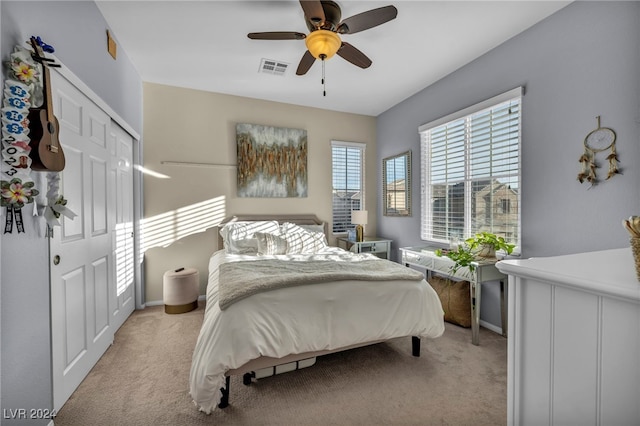 bedroom featuring ceiling fan, light colored carpet, and a closet