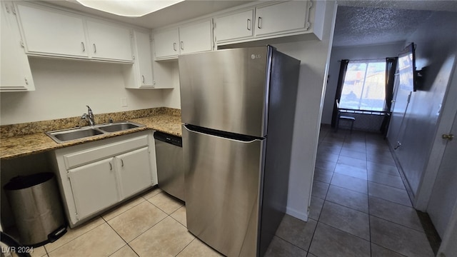 kitchen with white cabinets, light tile patterned floors, stainless steel appliances, and sink