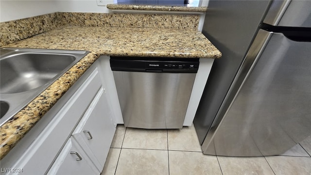 kitchen with white cabinets, stainless steel appliances, and light tile patterned flooring