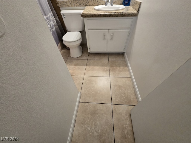 bathroom featuring tile patterned flooring, vanity, and toilet