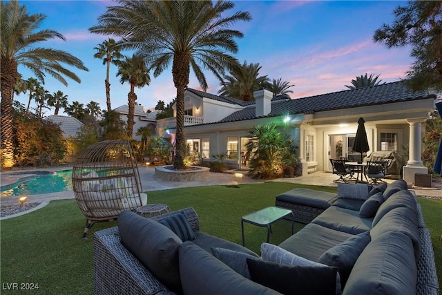 exterior space featuring outdoor lounge area, a patio area, and a lawn