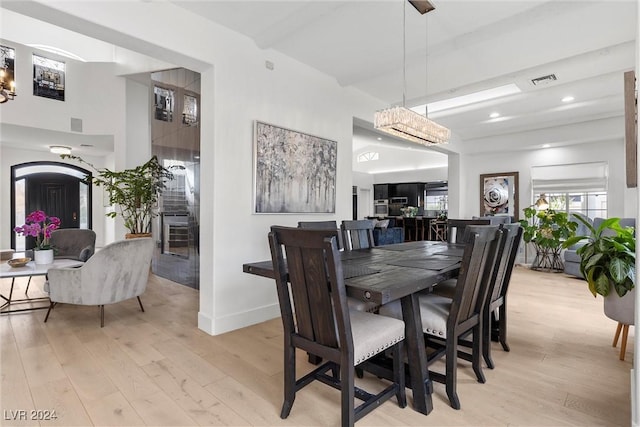 dining space featuring a high ceiling and light hardwood / wood-style flooring