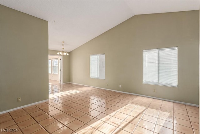 spare room featuring lofted ceiling, light tile patterned floors, and a chandelier