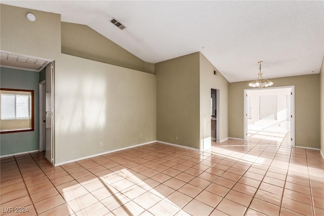 tiled empty room featuring vaulted ceiling and a notable chandelier