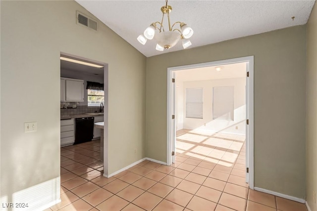 interior space with a textured ceiling, vaulted ceiling, sink, light tile patterned floors, and a notable chandelier